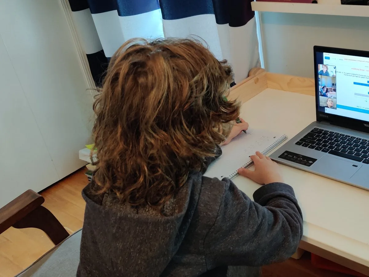 Student working on homework at a laptop at home